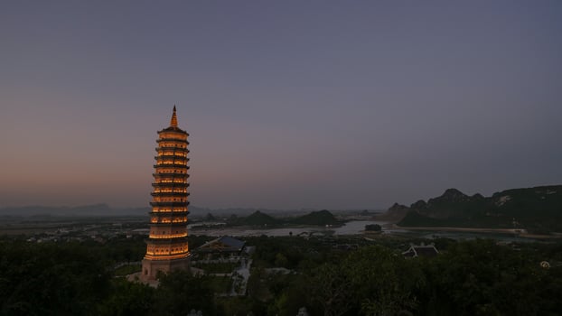 Illuminated Bai Dinh Pagoda tower at dusk photo
