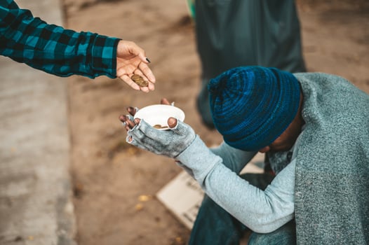 Beggar wrapped in cloth in the street accepting money photo