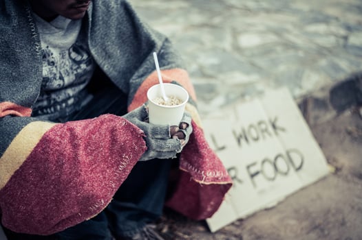 Homeless man wrapped in cloth and eating noodles photo
