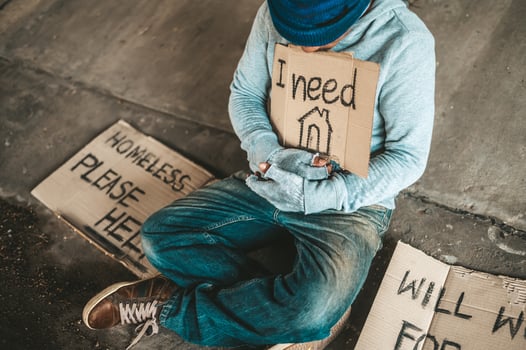 Beggars sitting under the bridge with a sign photo