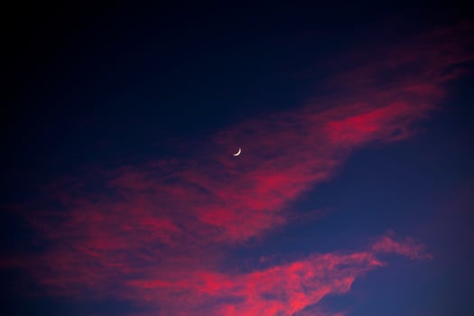 Crescent moon and red clouds with blue sky photo