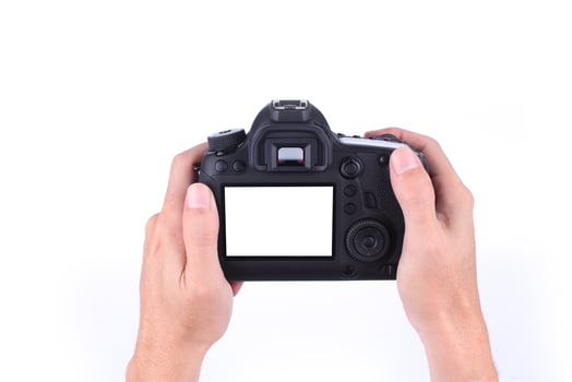 Hands holding DSLR camera on white background photo