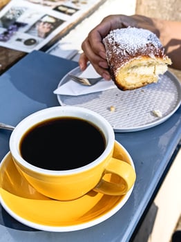 Close-up of person enjoying a sourdough cake bun and black coffee photo