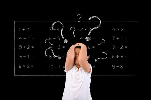 Young boy questions math problem on chalkboard photo