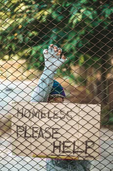 Beggars at a fence with homeless messages please help photo