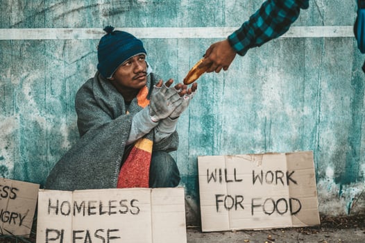 The bread-makers give to a beggar on the side of the road photo