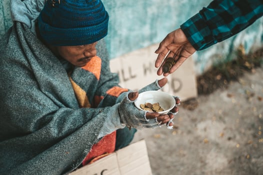 Person gives to a beggar on the side of the road photo
