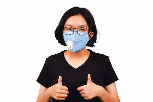 Young girl wear face mask and thumbs up for flighting Covid 19 photo
