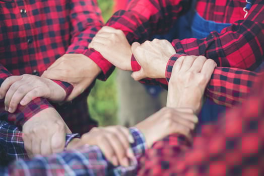 Close-up view of young people putting their hands together photo