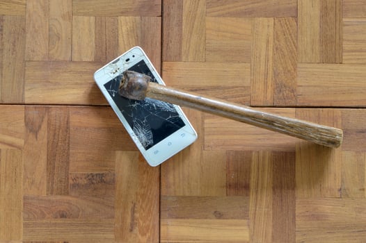 Broken smart phone smashed by hammer photo