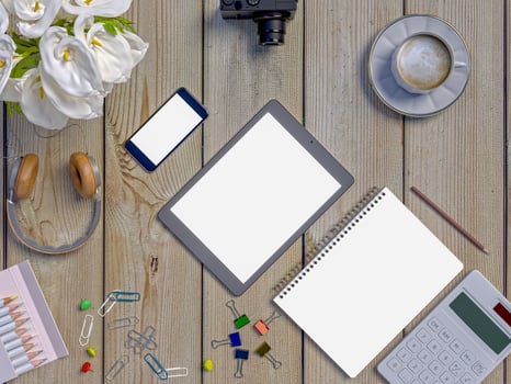 Mock up workspace on table with notebook, tablet, phone, headphones photo