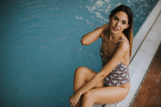 Beautiful young woman sitting by the swimming pool photo