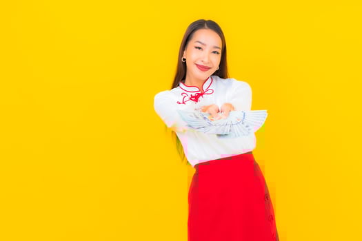 Beautiful young Asian woman sitting with a lot of cash photo
