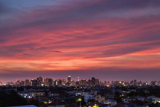 Pink clouds above a city at sunset photo