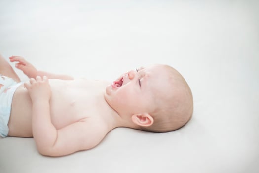 Cute baby girl crying on bed photo