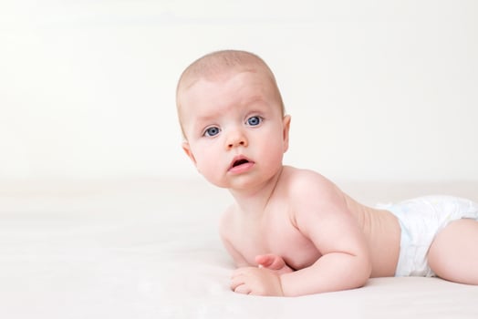 Cute baby girl lying on bed photo