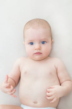 Cute baby girl lying on bed photo