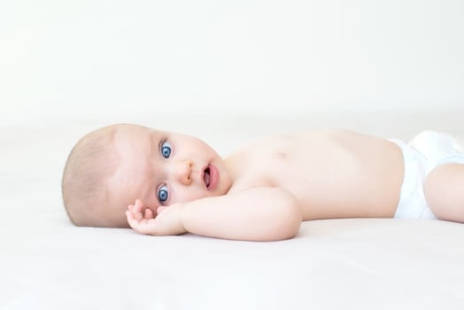 Cute baby girl lying on bed photo