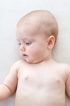 Cute baby girl lying on bed photo