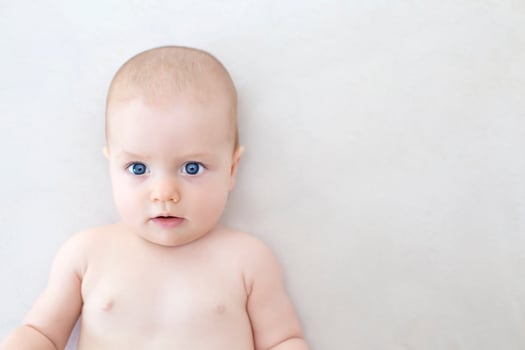 Cute baby girl lying on bed photo