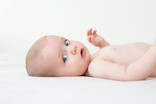 Cute baby girl lying on bed photo