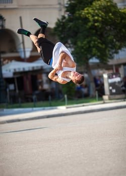 Man doing acrobatic tricks in a city street photo