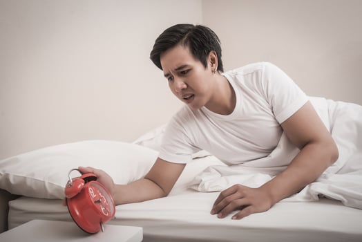 Man turns off the alarm clock in the morning photo