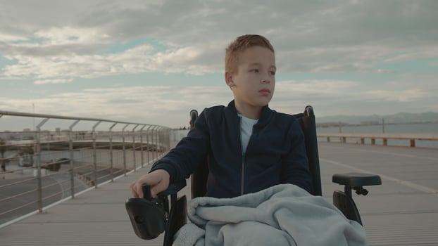 Boy in a wheelchair outside photo