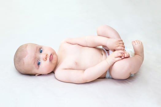 Cute baby girl lying on bed photo