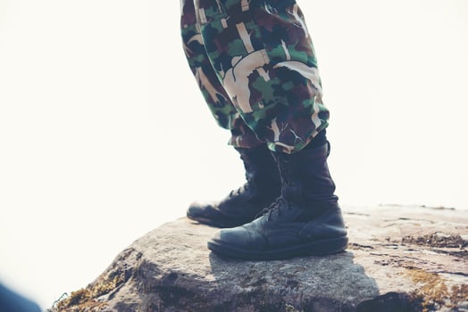 Soldier's feet on the rocks on the mountain photo