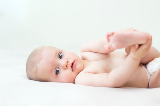 Cute baby girl lying on bed photo