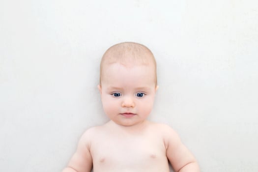 Cute baby girl lying on bed photo