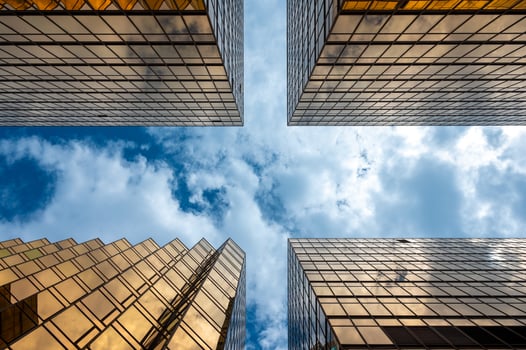 View looking up at skyscrapers with cloudy blue sky photo