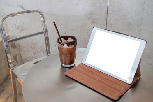 Mobile working in a coffee shop with blank screen tablet photo