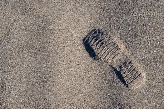 A shoe print on the beach sand photo