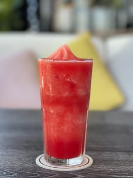 Watermelon smoothie in glass on gray table photo
