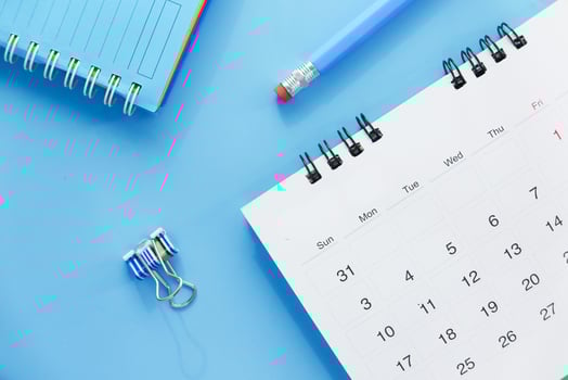 Calendar and pencil on blue background photo