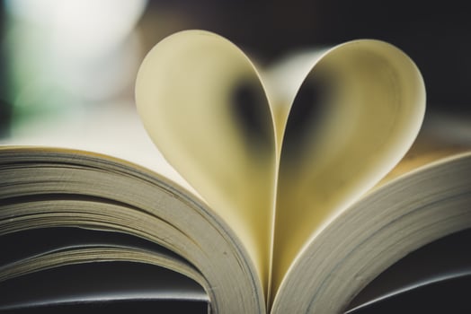 Curled paper heart shape with blurred bokeh of cafe photo