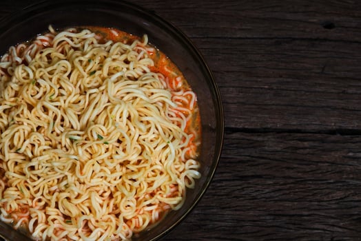 Instant noodles in a bowl on wooden background photo