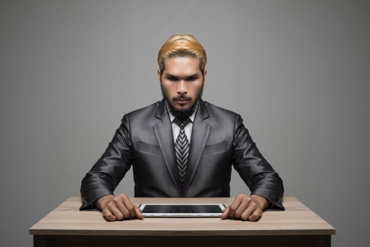 Handsome young businessman working with touchpad while sitting in office photo