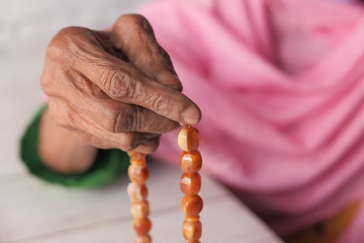 Old woman's hand with prayer beads photo