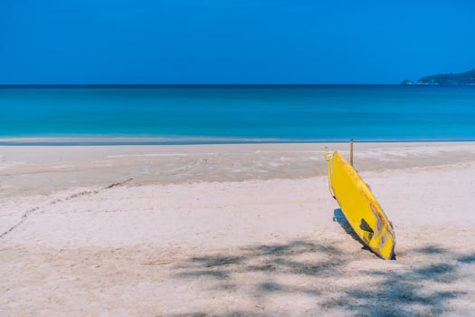 Surfboard at summer beach with sunlight and blue sky photo