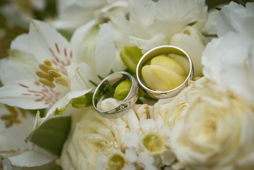 Wedding rings on a bouquet of white flowers photo