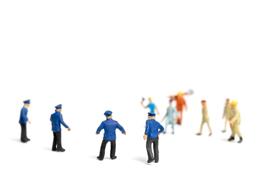 Miniature police and an angry mob on a white background photo
