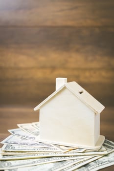Money and house model on a wooden background, finance and banking concept photo
