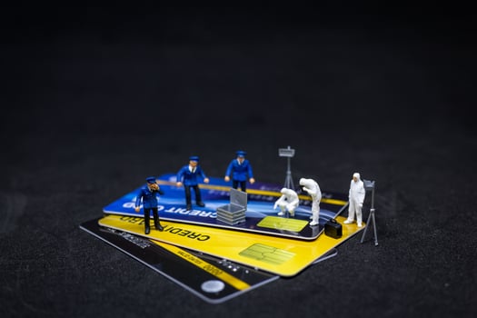 Miniature police and detectives at a crime scene on credit cards, cybercrime concept photo