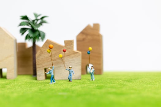 Miniature family walking in a field with balloons, happy family time concept photo