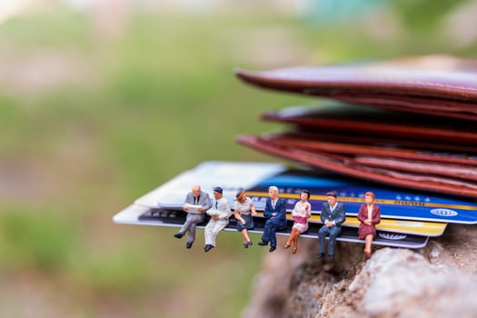 Miniature businesspeople sitting on a credit card, business and finance concepts photo