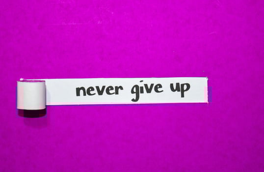 Never give up text, Inspiration, Motivation and business concept on purple torn paper photo