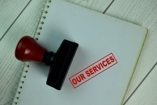 Red handle rubber stamper and our services text isolated on table photo